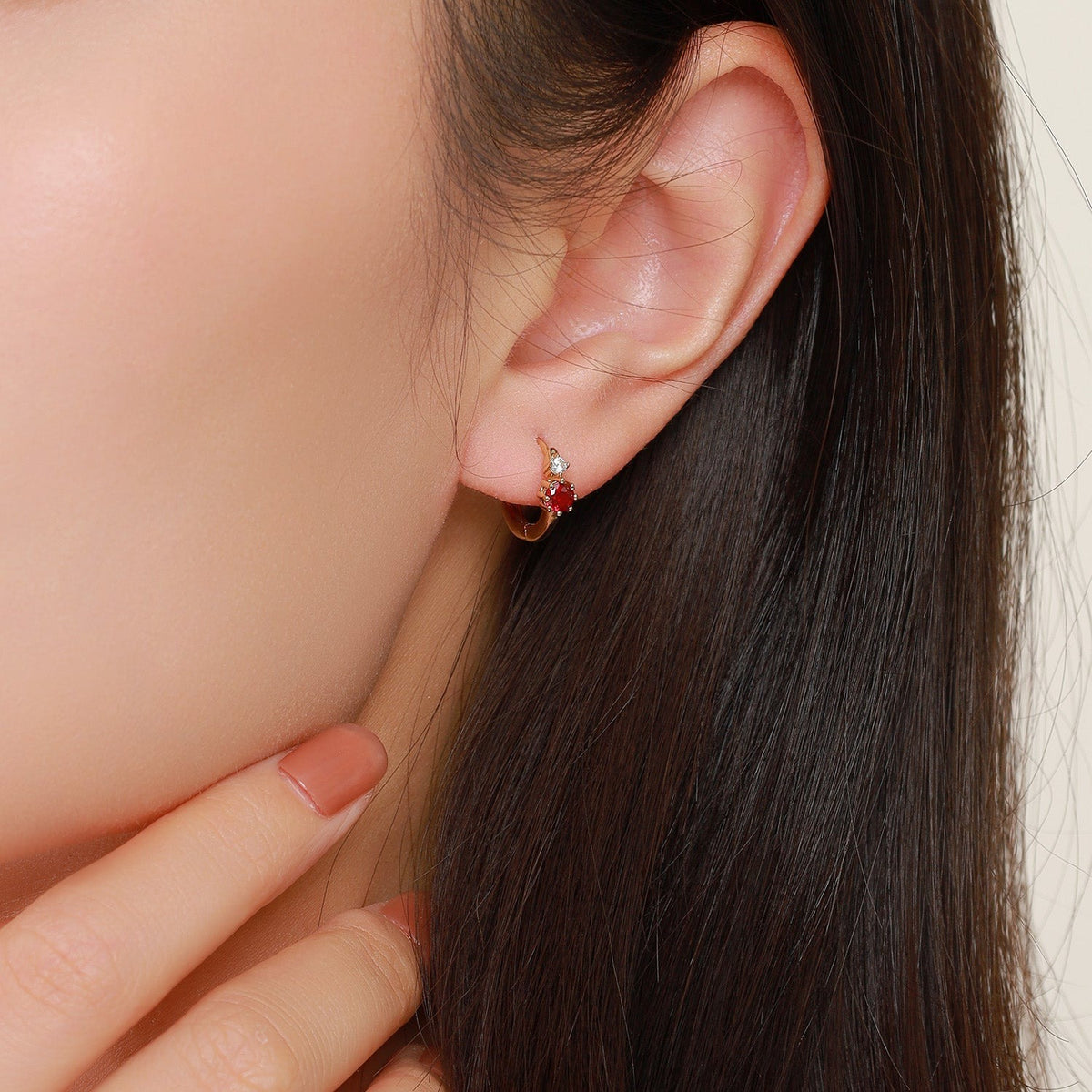 Scarlatta red cubic zirconia huggie hoop earring worn on the ear